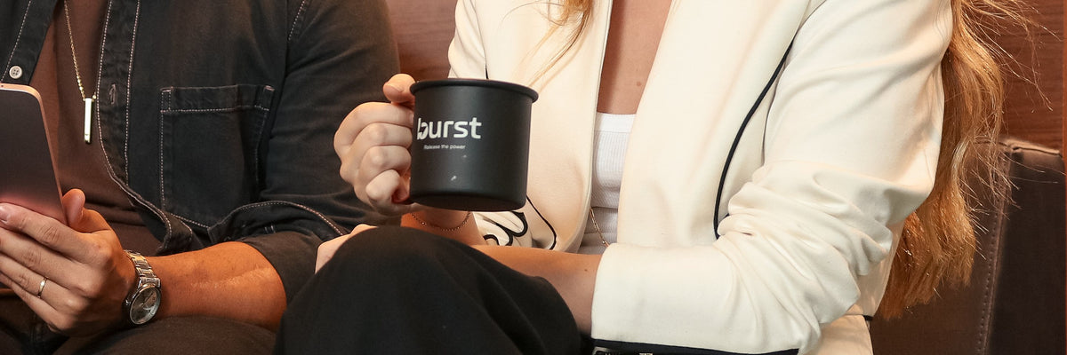 Duas pessoas no sofá; uma segura a caneca Burst